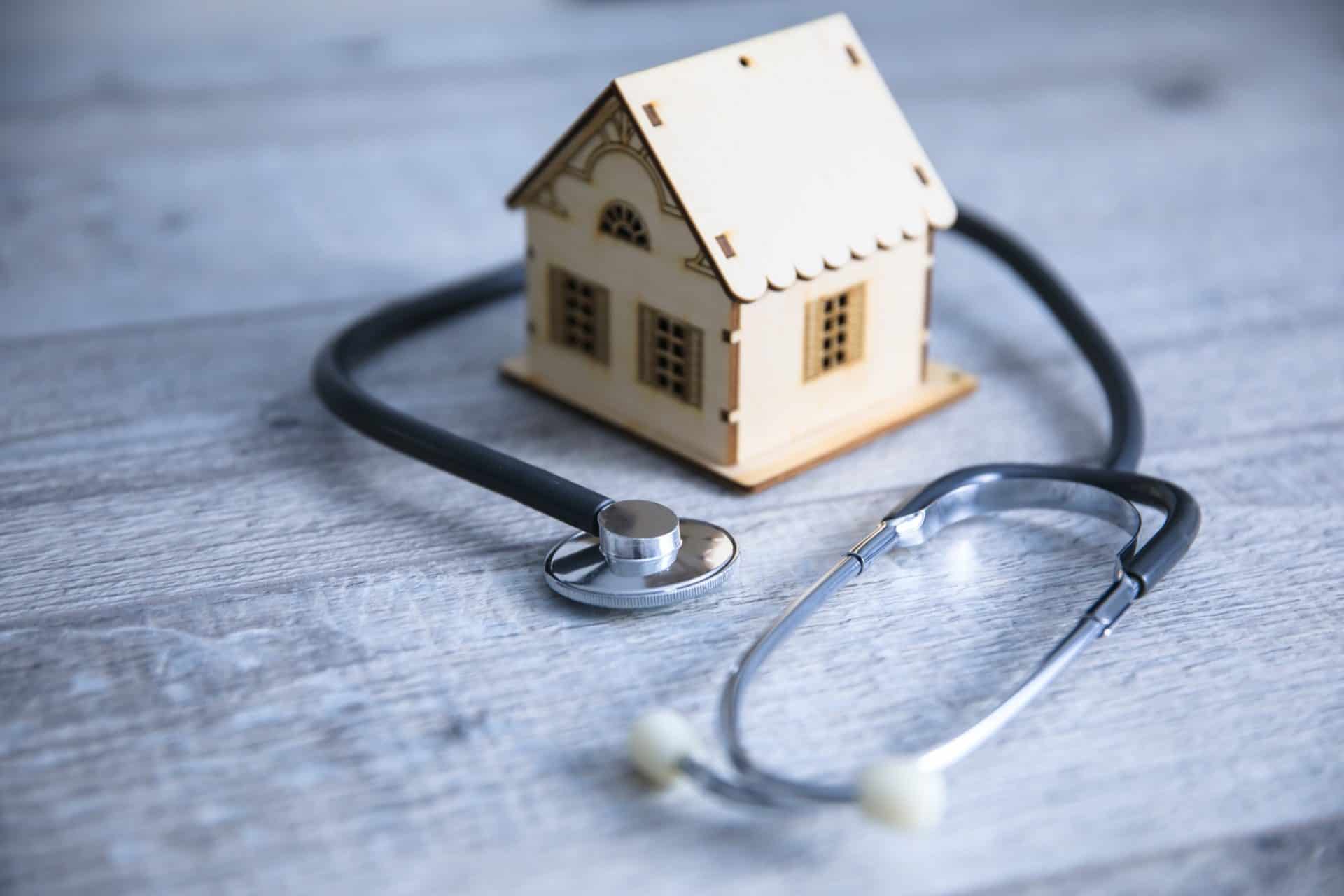 Small home with stethoscope indicating insurance report